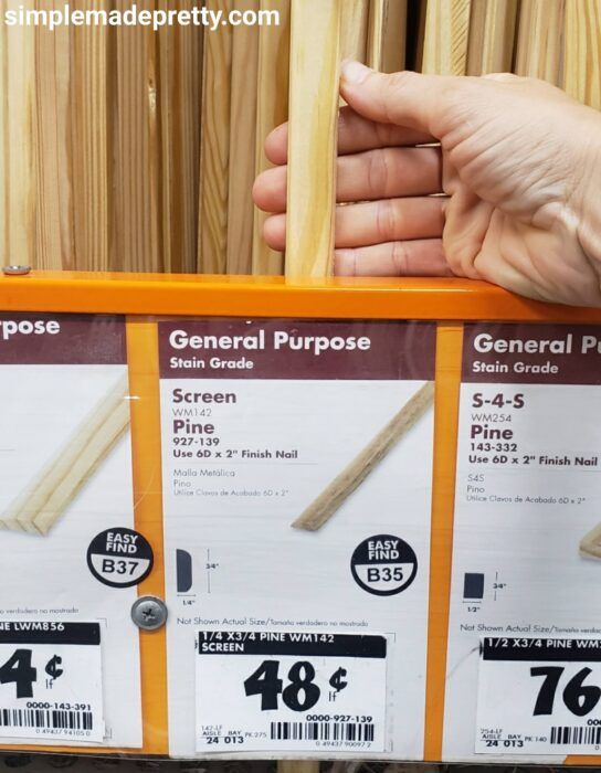 a person holding some wood sticks in front of the store's price label for general purpose