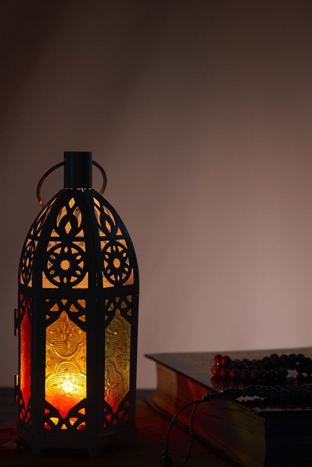 a lit lantern sitting on top of a wooden table