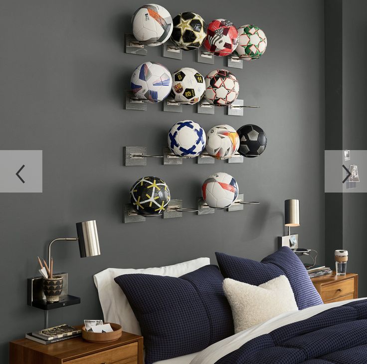 a bedroom with soccer balls mounted to the wall and shelves on the wall above it