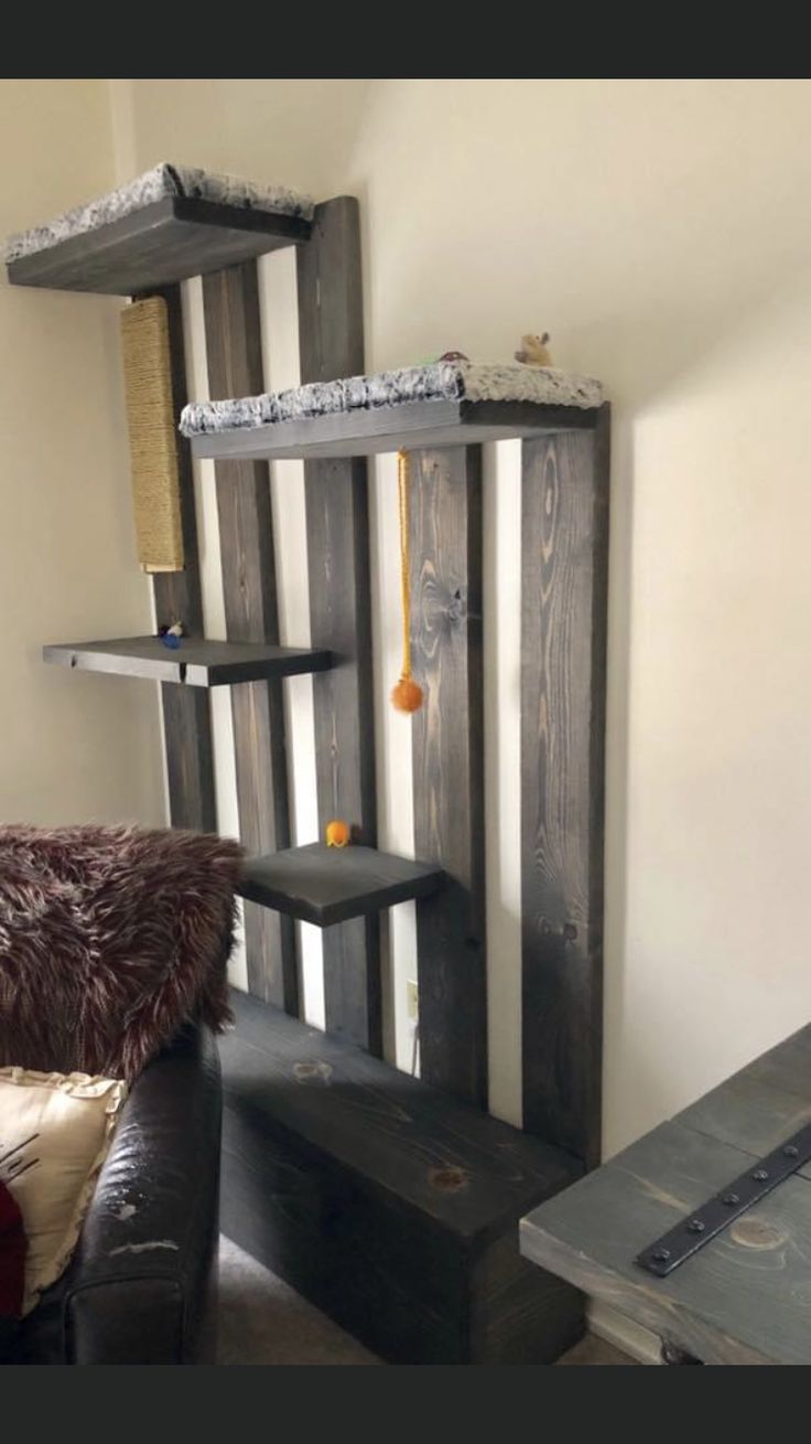 a living room filled with furniture next to a wall mounted bookshelf in the corner