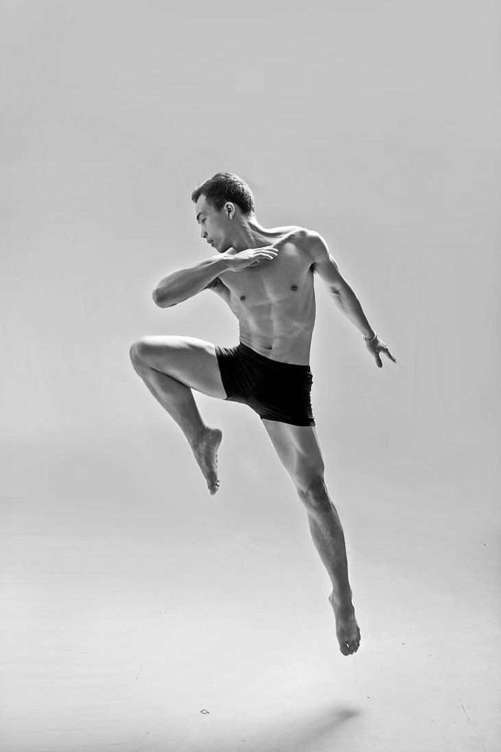 a shirtless man in black and white is doing a kickbox dance move with one leg up