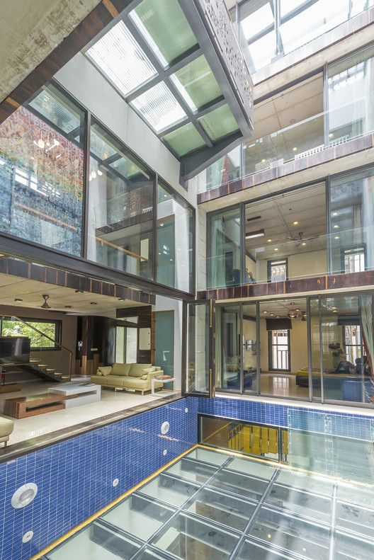 an indoor swimming pool in a large building with lots of windows on the ceiling and floor