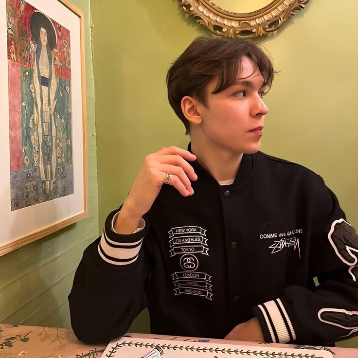 a young man sitting at a table in front of a cake