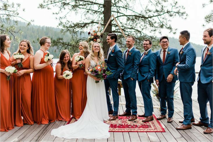 a group of people standing next to each other on a wooden floor in front of a tree