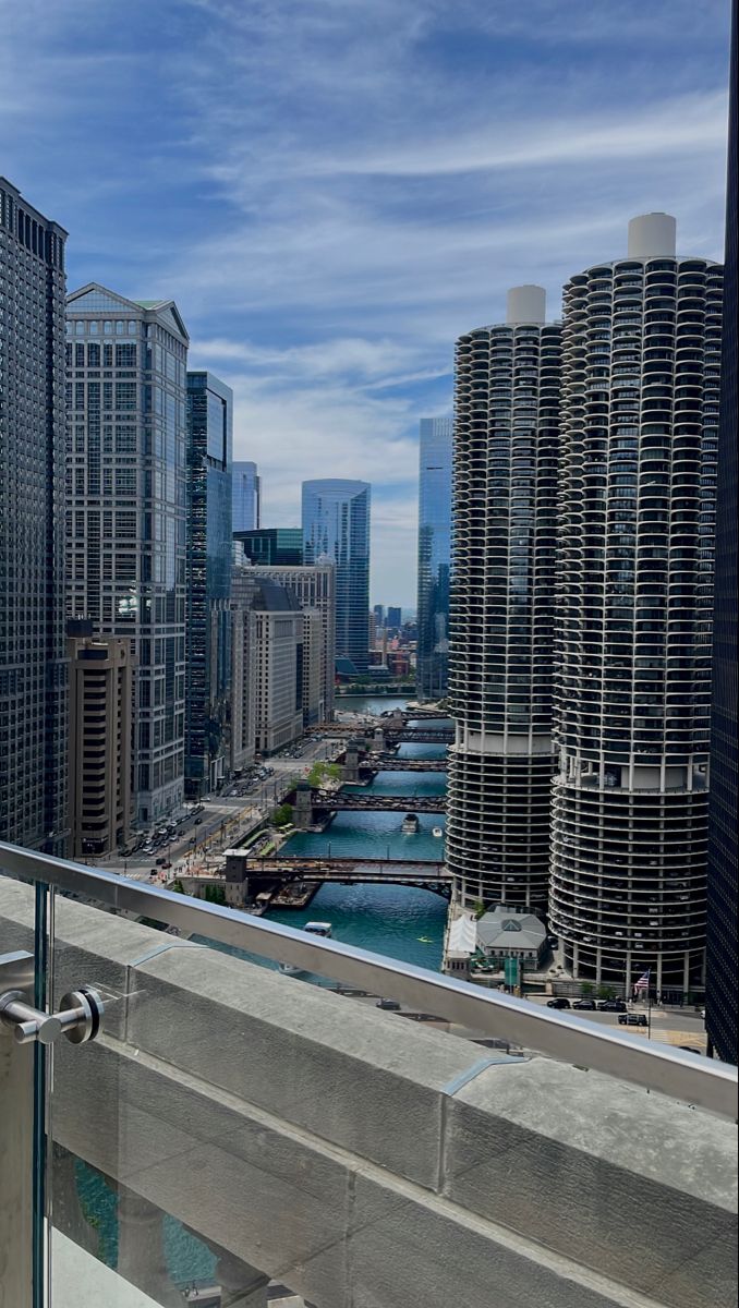 a balcony with a view of the river and buildings in chicago, illinois on a sunny day