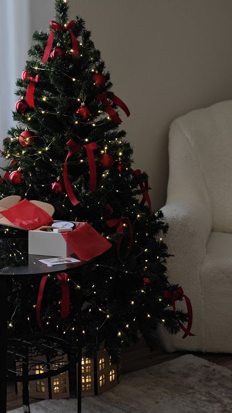 a small christmas tree with red bows and presents