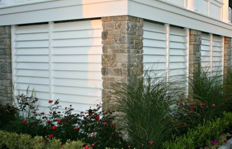 flowers and plants in front of a white house