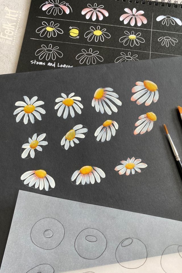 the flowers are being drawn on paper with markers