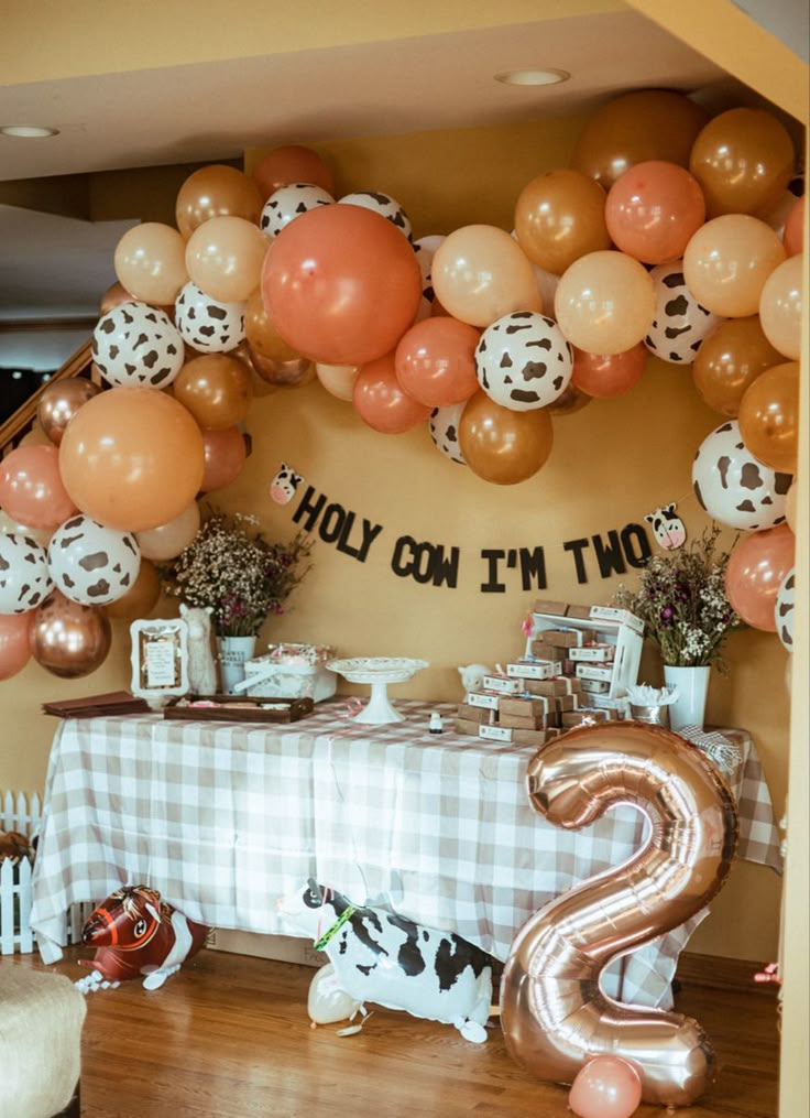 the table is set up for a party with balloons and decorations on it, along with an animal theme