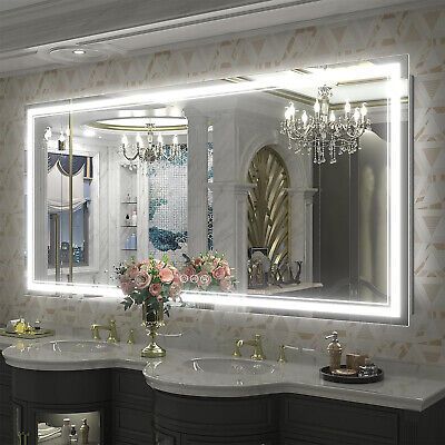 a bathroom with two sinks and a large mirror over it's sink area in front of a chandelier