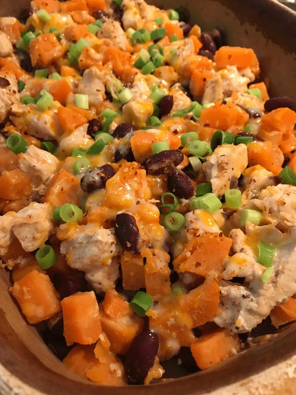 a casserole dish with chicken, black beans and carrots