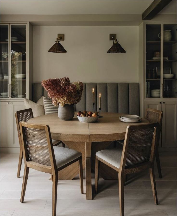 a dining room table with two chairs and a vase filled with flowers on top of it