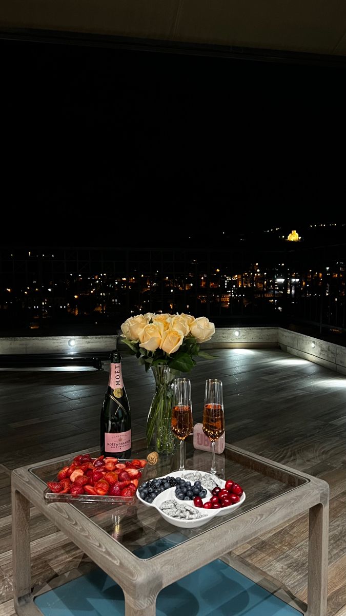 a table that has some food and drinks on it with flowers in the vases