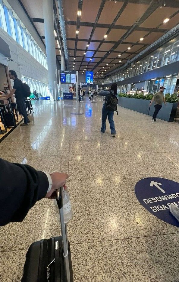 a person pulling a suitcase through an airport