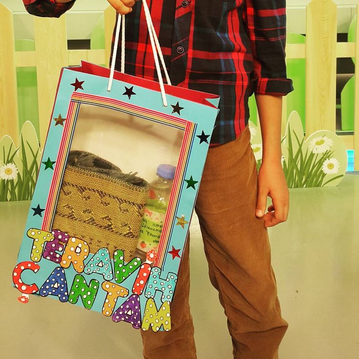 a young boy holding a bag with the words happy birthday written on it and stars