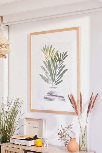 a painting hanging on the wall above a table with vases and plants in front of it