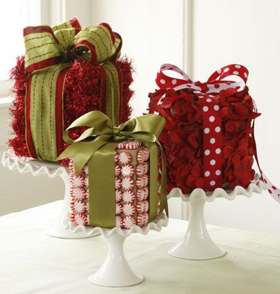 two wrapped presents sitting on top of a cake stand