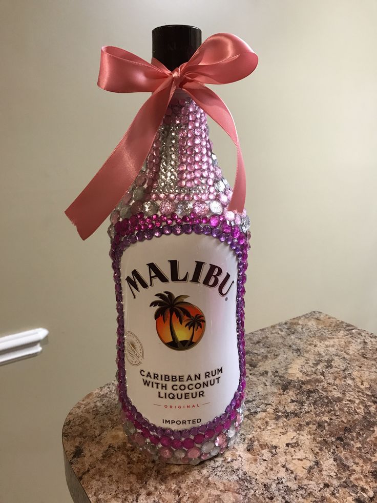 a bottle that has some kind of liquid in it with a pink ribbon around it