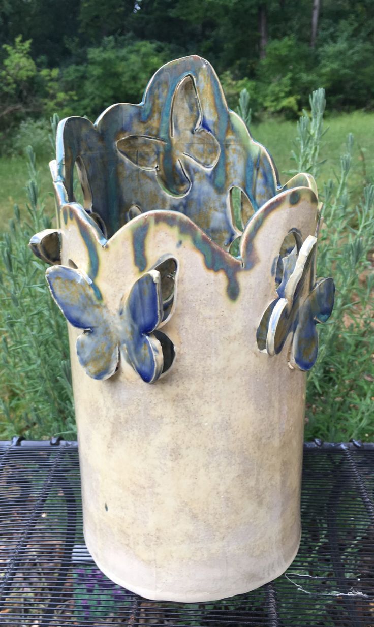 a decorative vase sitting on top of a metal grill