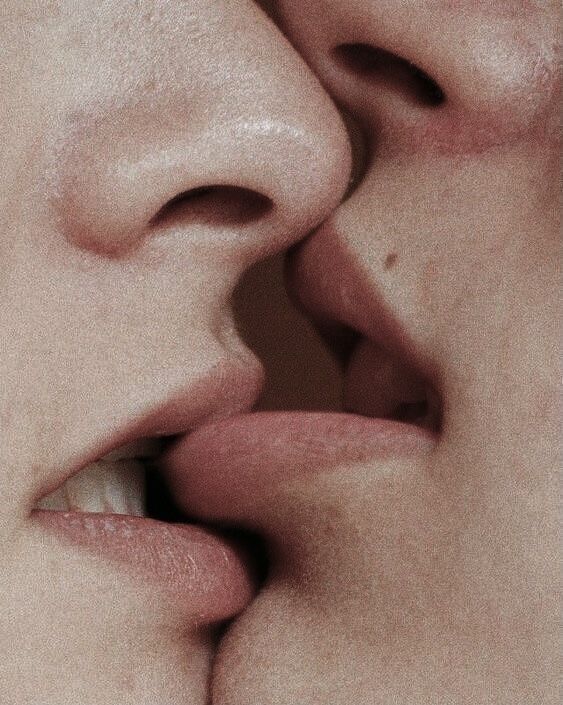 two people kissing each other with their noses close together