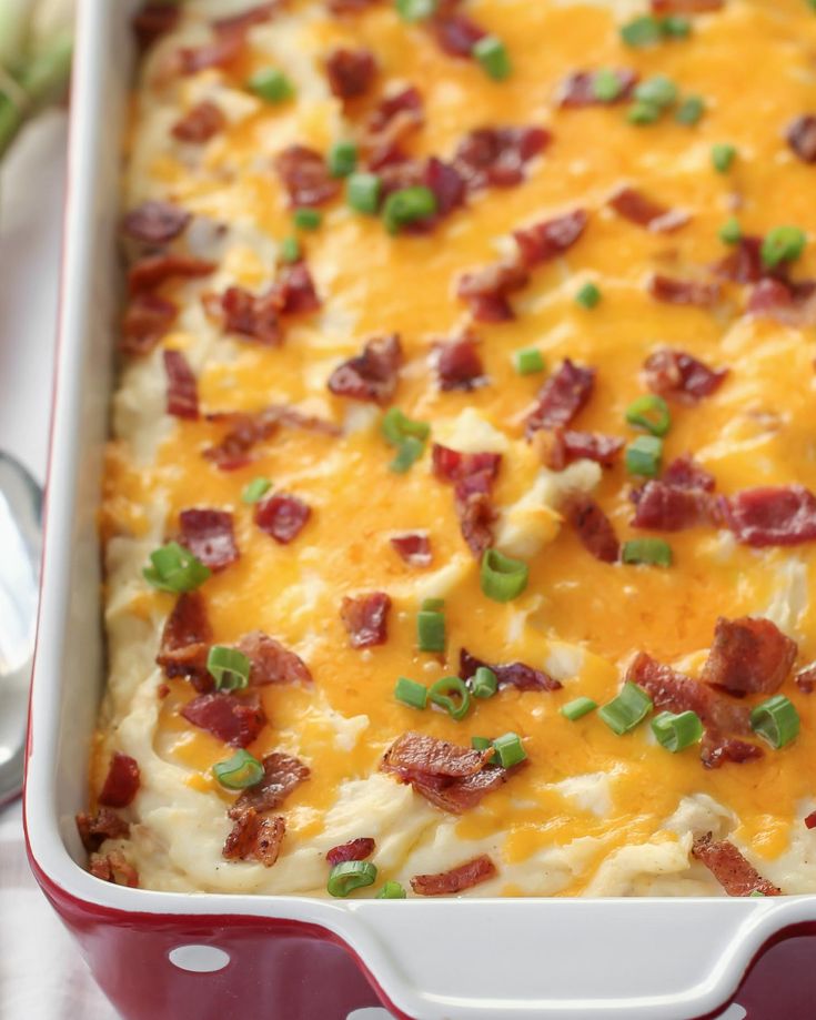 a casserole dish with bacon, cheese and green onions