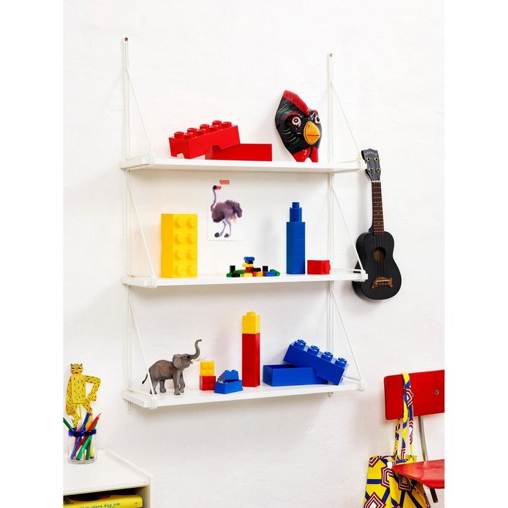 a white shelf with legos, toys and a guitar hanging on it's side