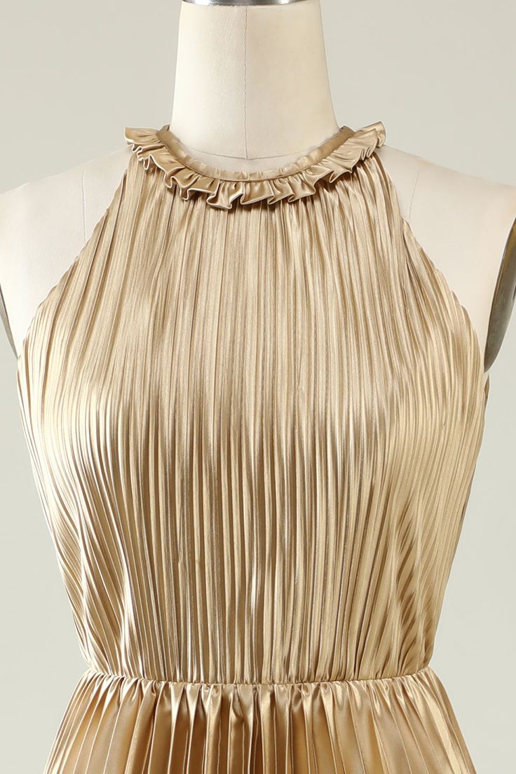 a gold dress on a mannequin dummy with an open back and pleated neckline