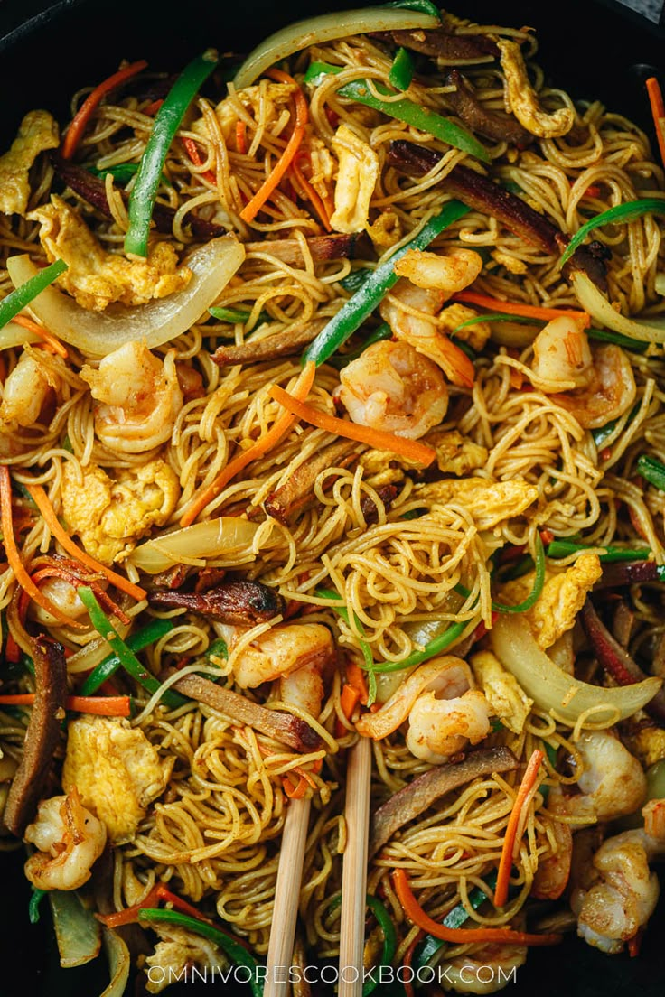 stir fried noodles with shrimp and vegetables in a skillet