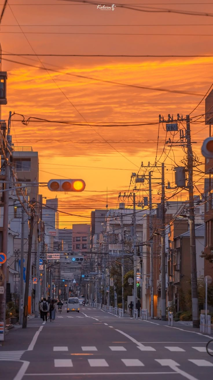 the sun is setting over an empty city street