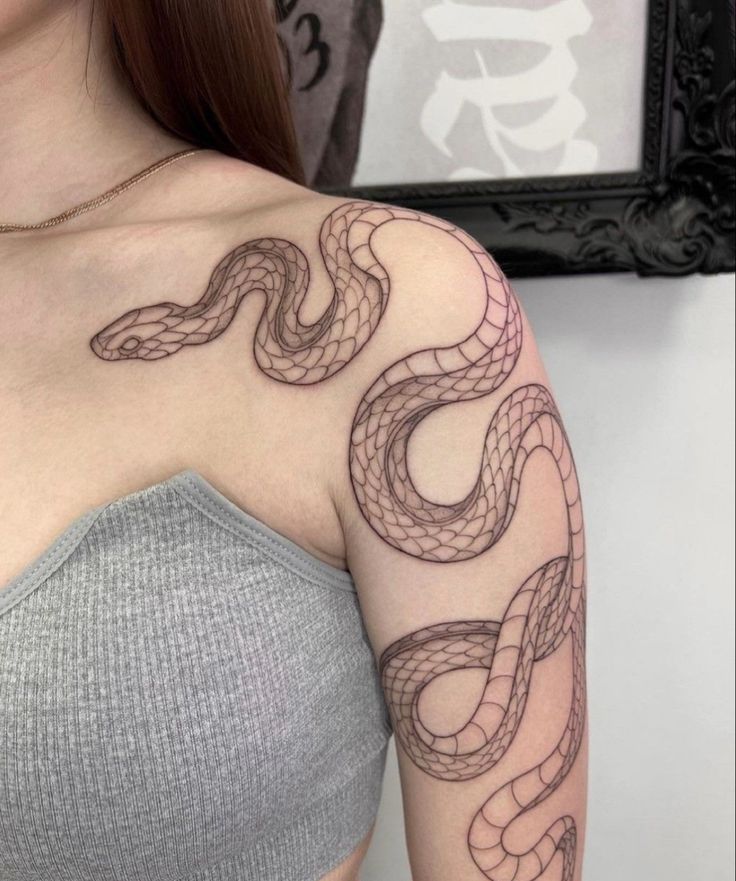 a woman with a snake tattoo on her shoulder