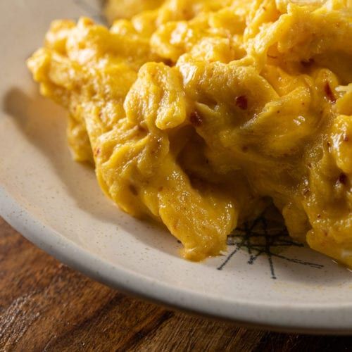 scrambled eggs on a plate with a fork