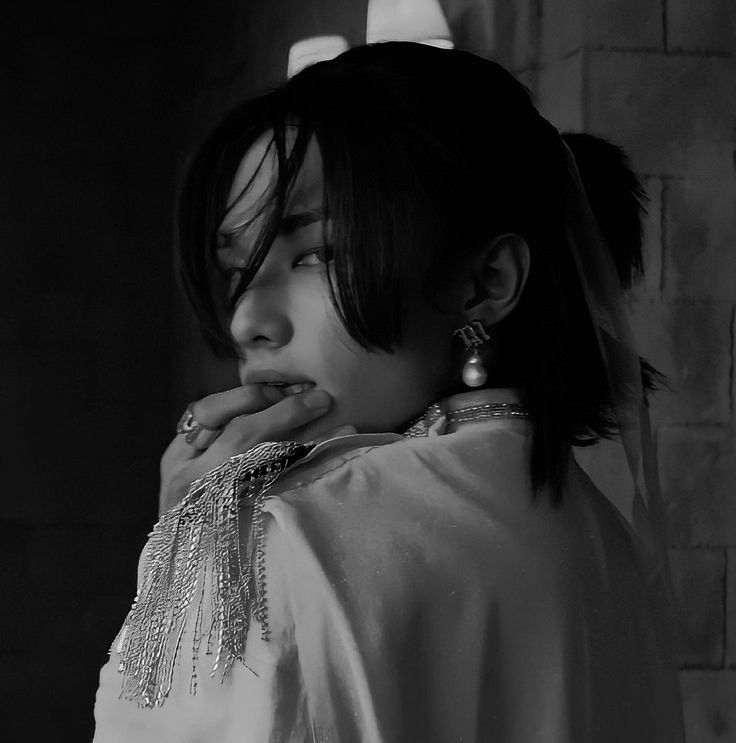 black and white photograph of a woman with her hand on her mouth, wearing jewelry