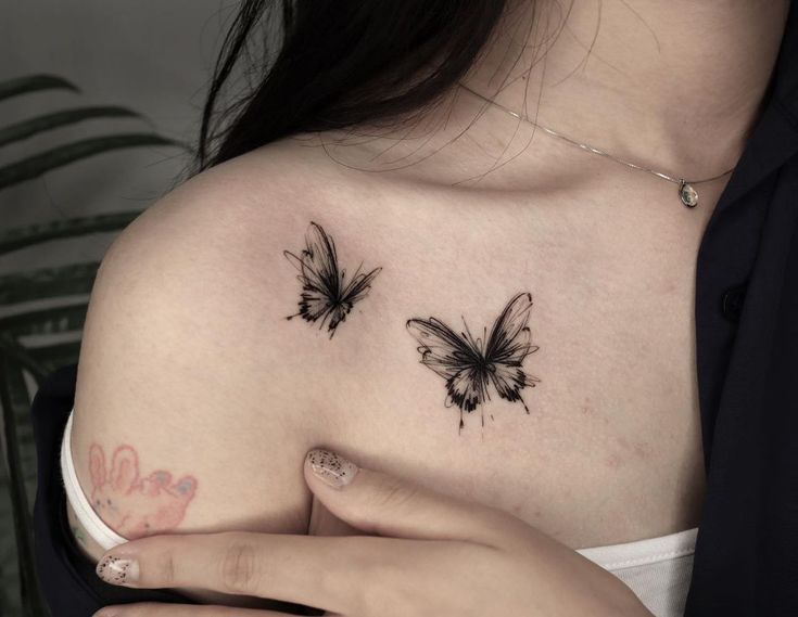 a woman's shoulder with two butterflies on her left side and the other half of her chest