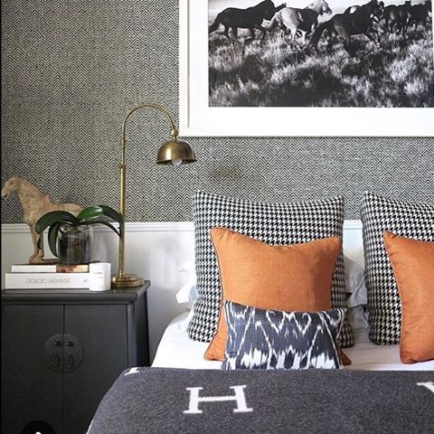 a bed with two pillows on it and an animal print wallpaper behind the headboard