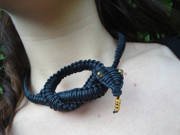 a close up of a woman wearing a blue necklace with a yellow tag on it