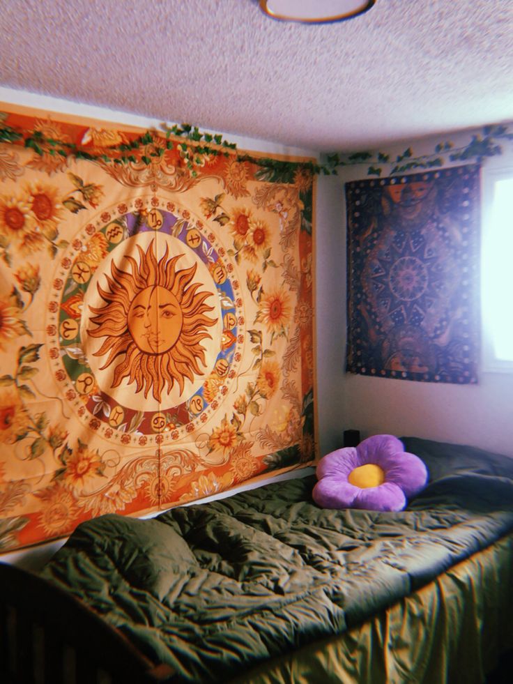 a bedroom with a sun tapestry on the wall and a bed in front of it