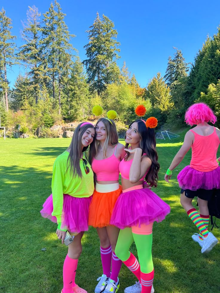 three girls dressed up in colorful outfits posing for the camera with their arms around each other