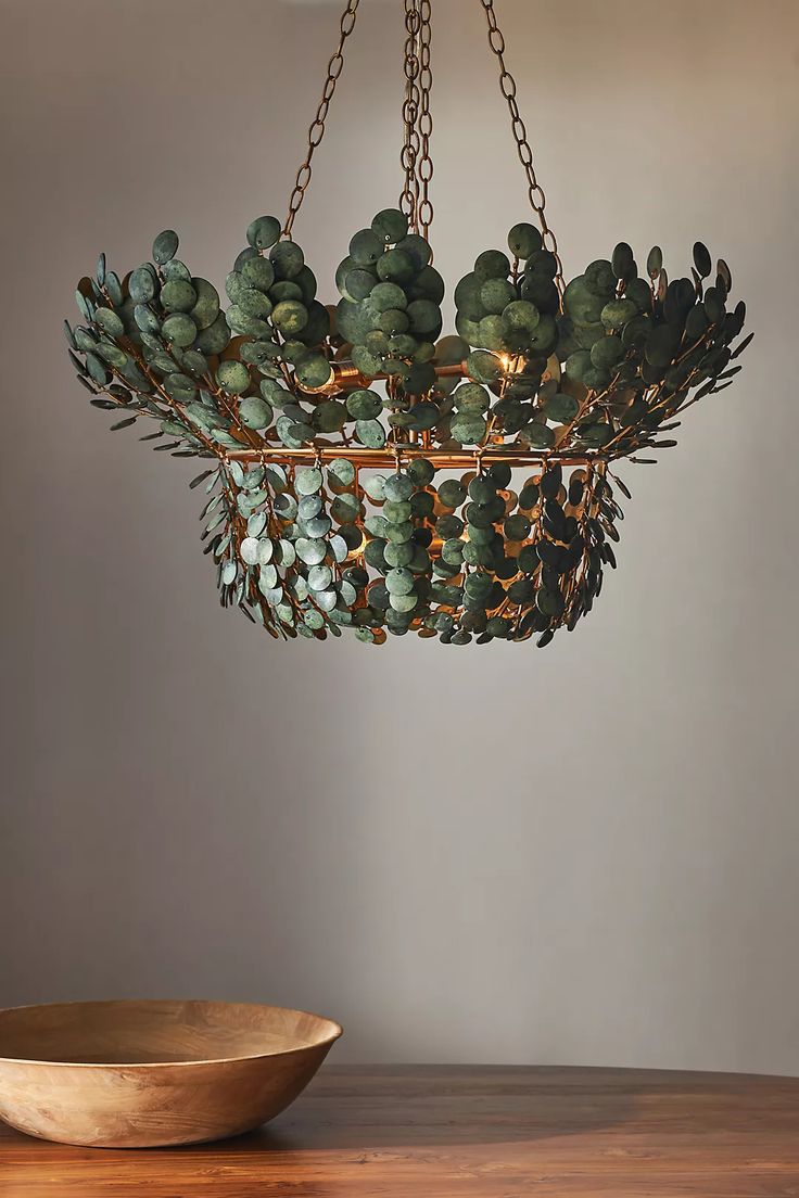 a bowl sitting on top of a wooden table next to a light fixture hanging from the ceiling