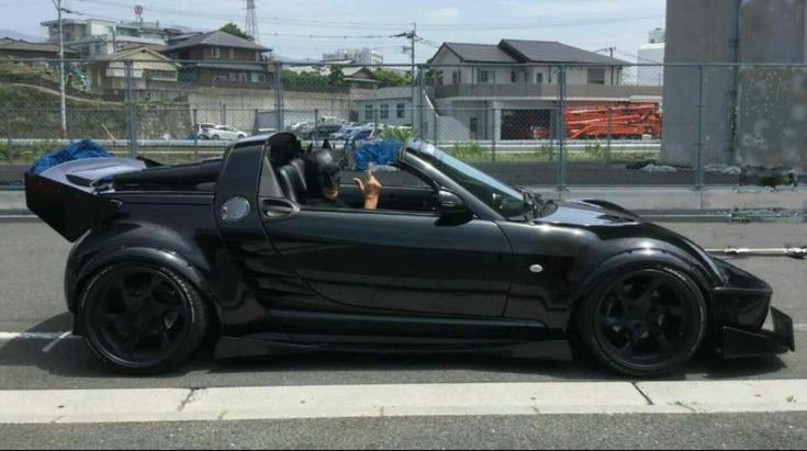 a small black car parked on the side of the road