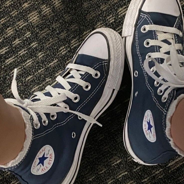 someone is wearing blue converse shoes on the carpet