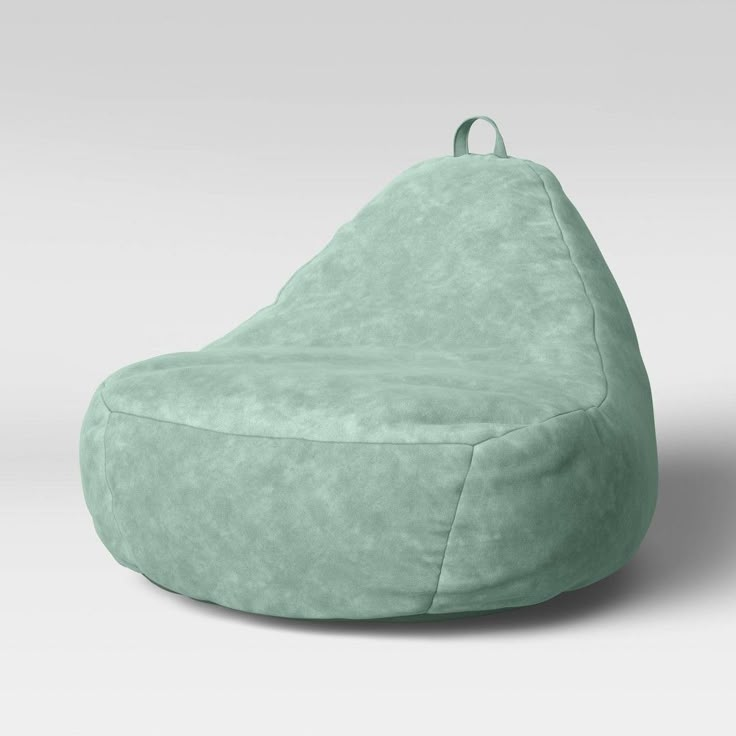 a green bean bag chair sitting on top of a white floor