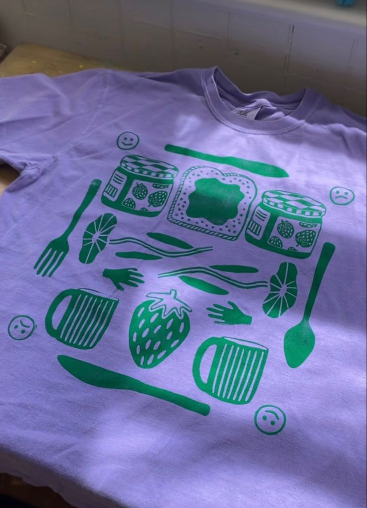 a purple shirt with green images on it