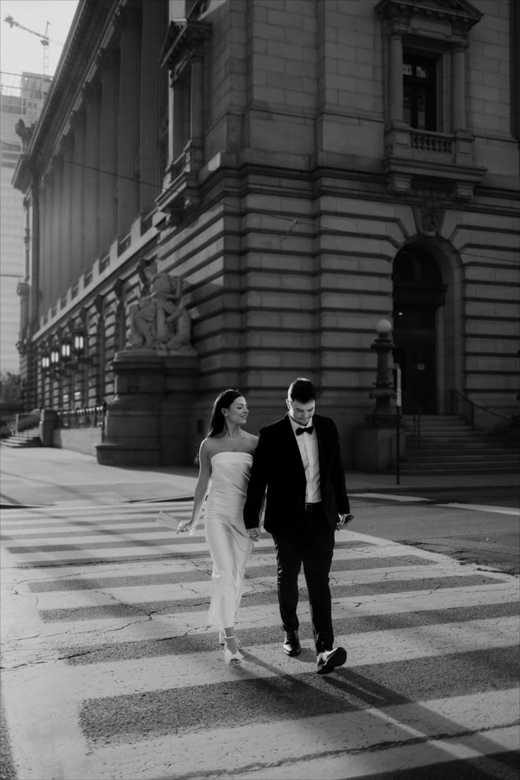 a man and woman are walking across the street