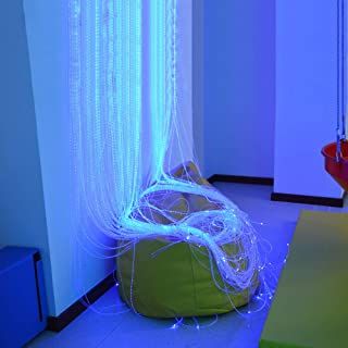 a bean bag chair sitting in front of a window covered in white stringing and lights