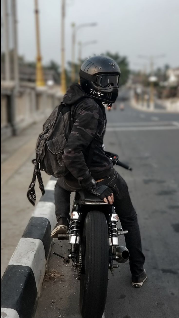 a man riding on the back of a motorcycle down a street