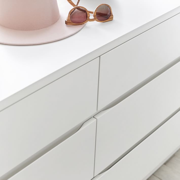 a pink hat and sunglasses sitting on top of a white dresser