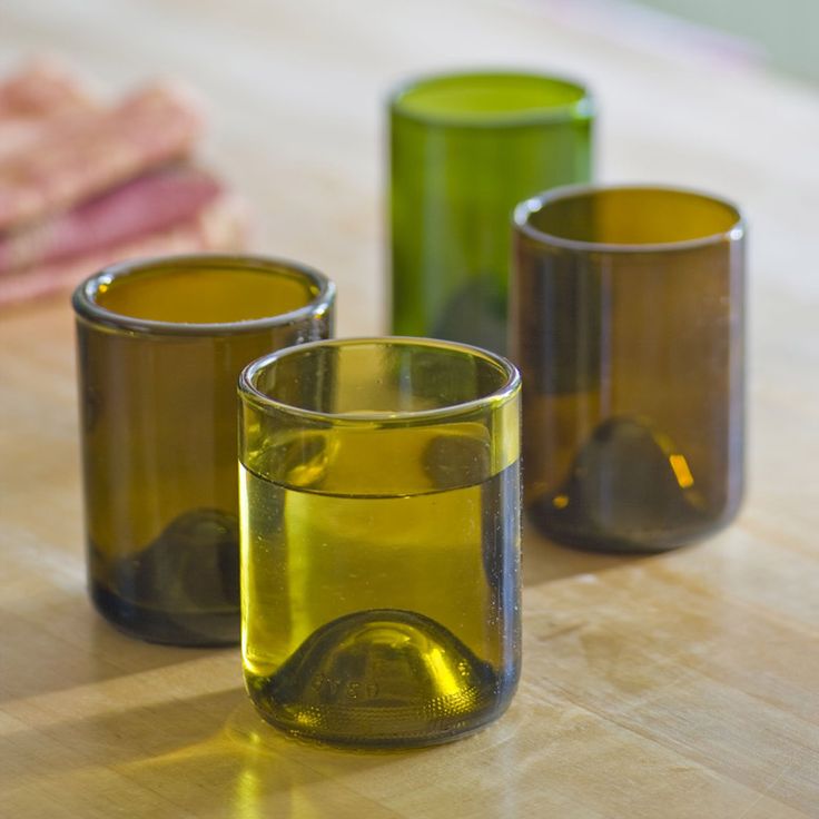 three glasses sitting on top of a wooden table next to each other with the words wine bottle glasses