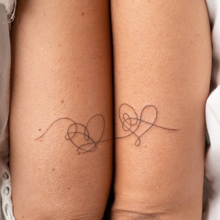 two people with tattoos on their legs, one is holding the other's arm