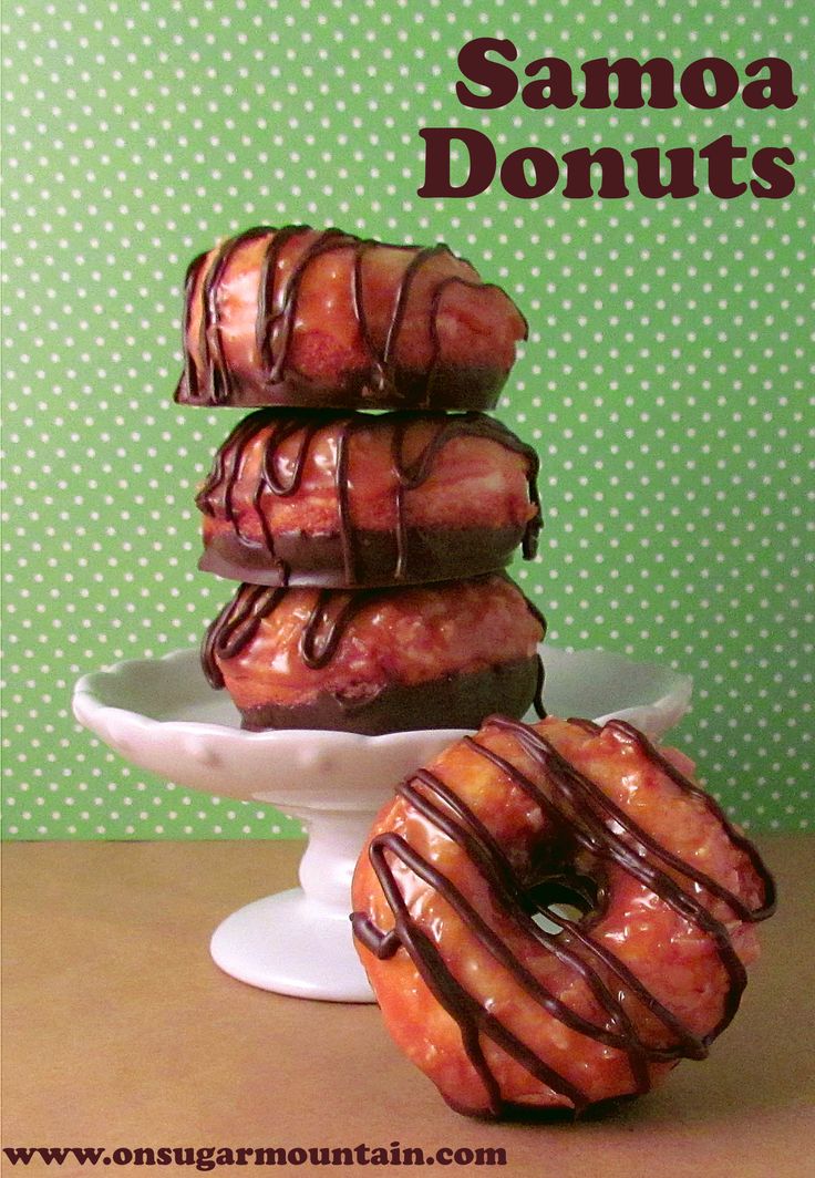 there are three donuts on the plate and one is drizzled with chocolate