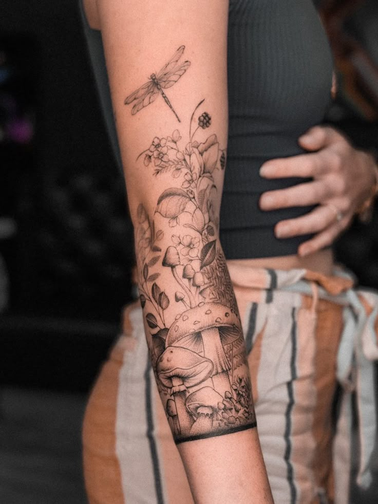 a woman with a dragon tattoo on her arm and the other arm behind her back